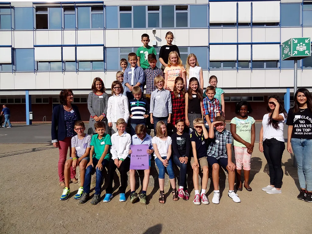 Klassenfoto einer neuen fünften Klasse auf dem Schulhof.